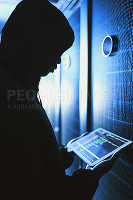 Buy stock photo Shot of a hacker using a digital tablet in a server room