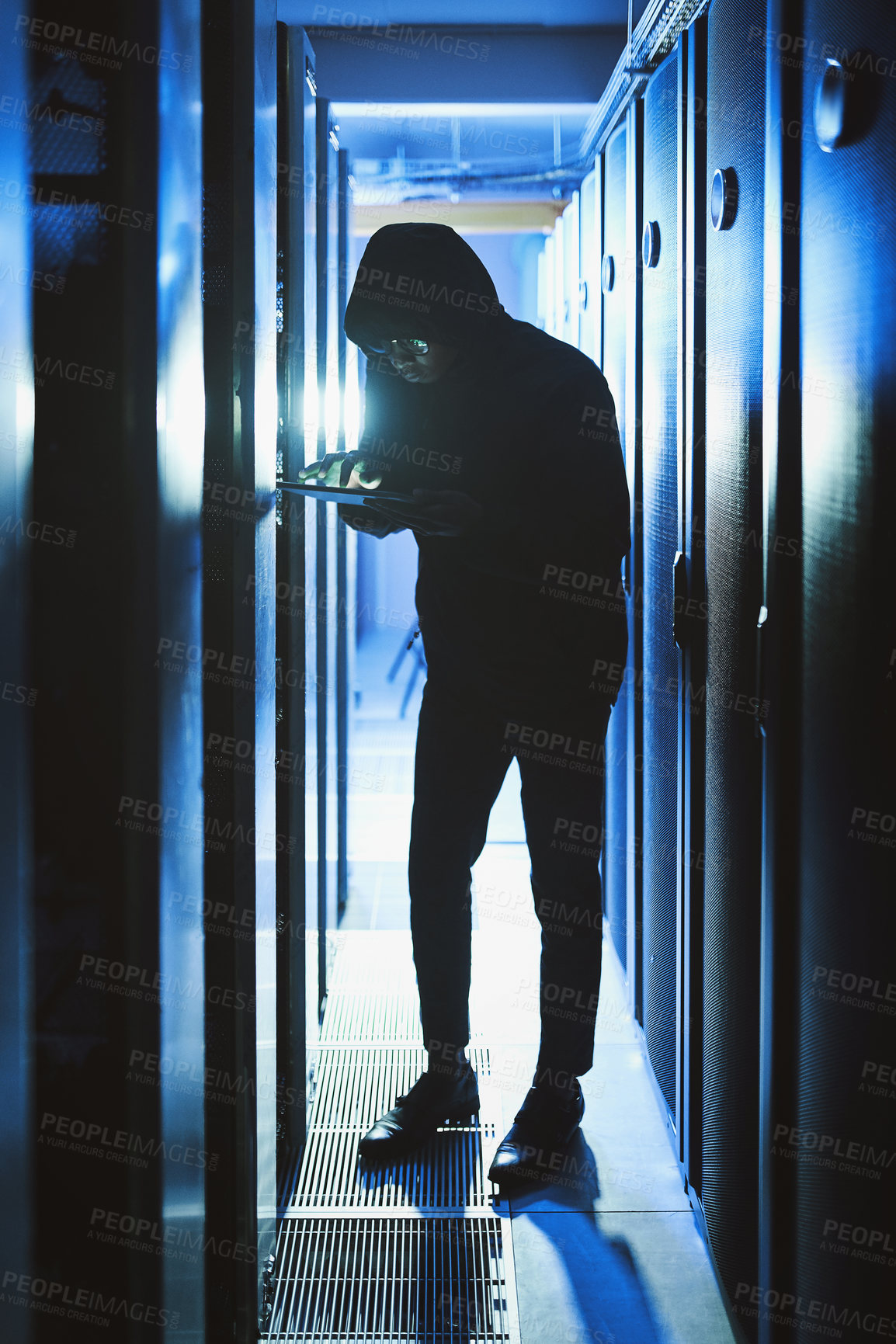 Buy stock photo Shot of a hacker using a digital tablet in a server room