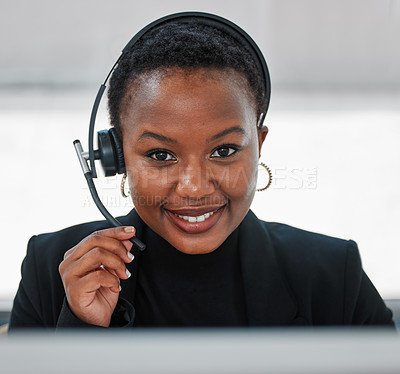 Buy stock photo Shot of a young woman using a headset and computer
at work in a modern office