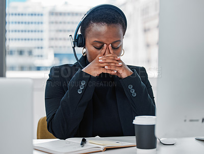 Buy stock photo Shot of a young woman feeling stressed while using a headset and computer late at night in a modern office