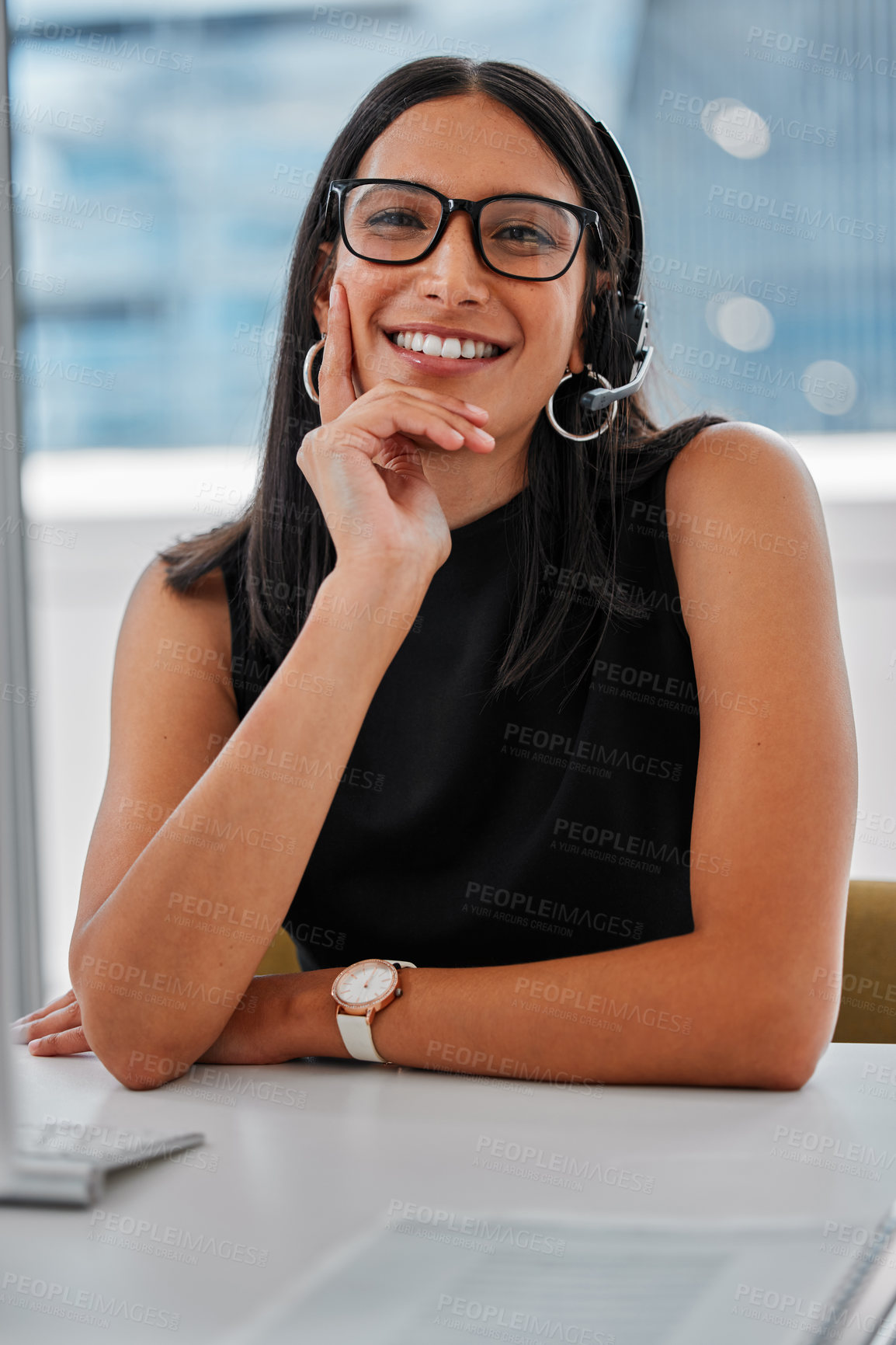 Buy stock photo Shot of a young woman using a headset and computer
at work in a modern office