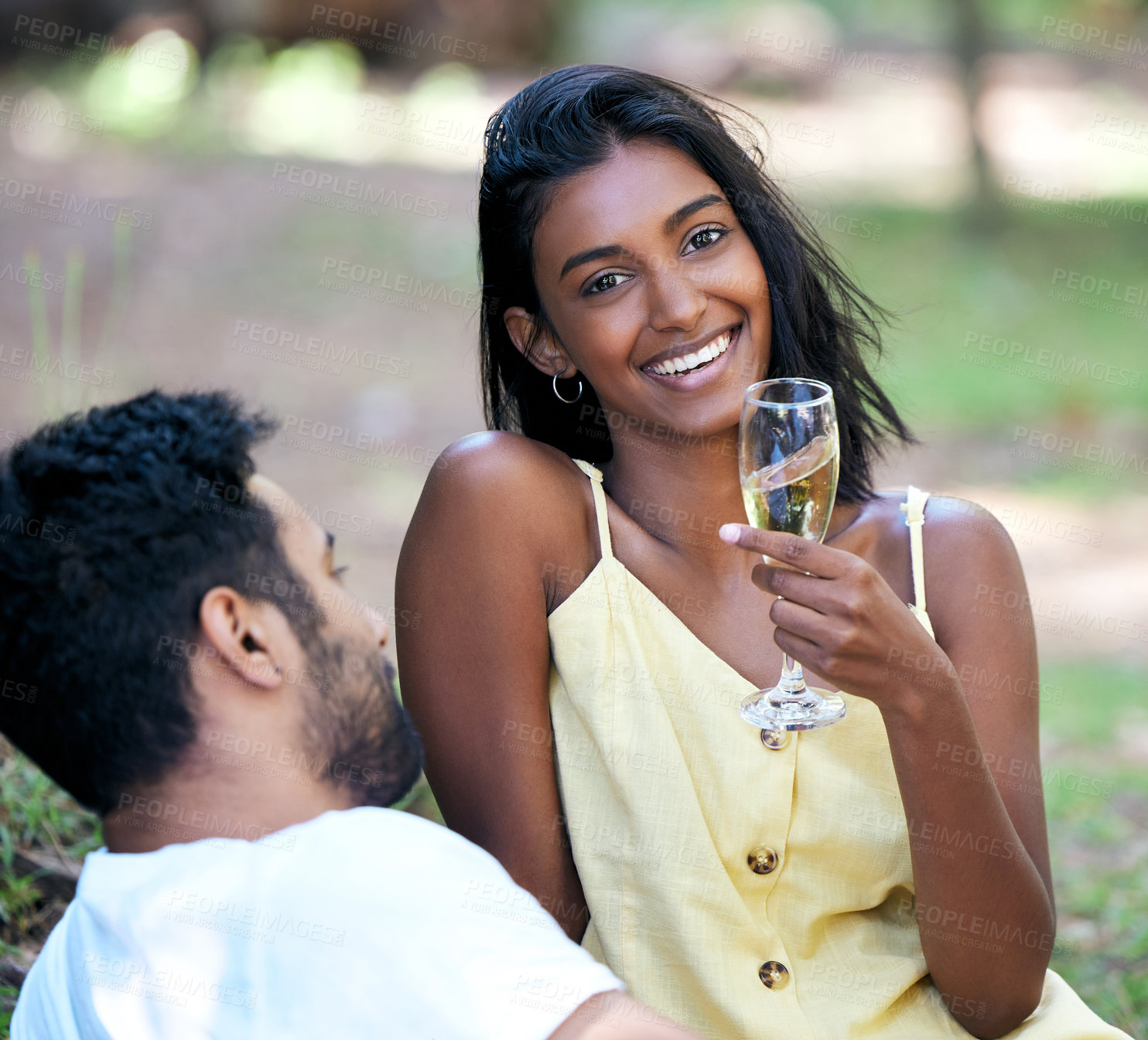 Buy stock photo Shot of a young woman drinking champagne while on a date at the park
