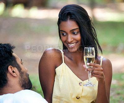 Buy stock photo Shot of a young woman drinking champagne while on a date at the park