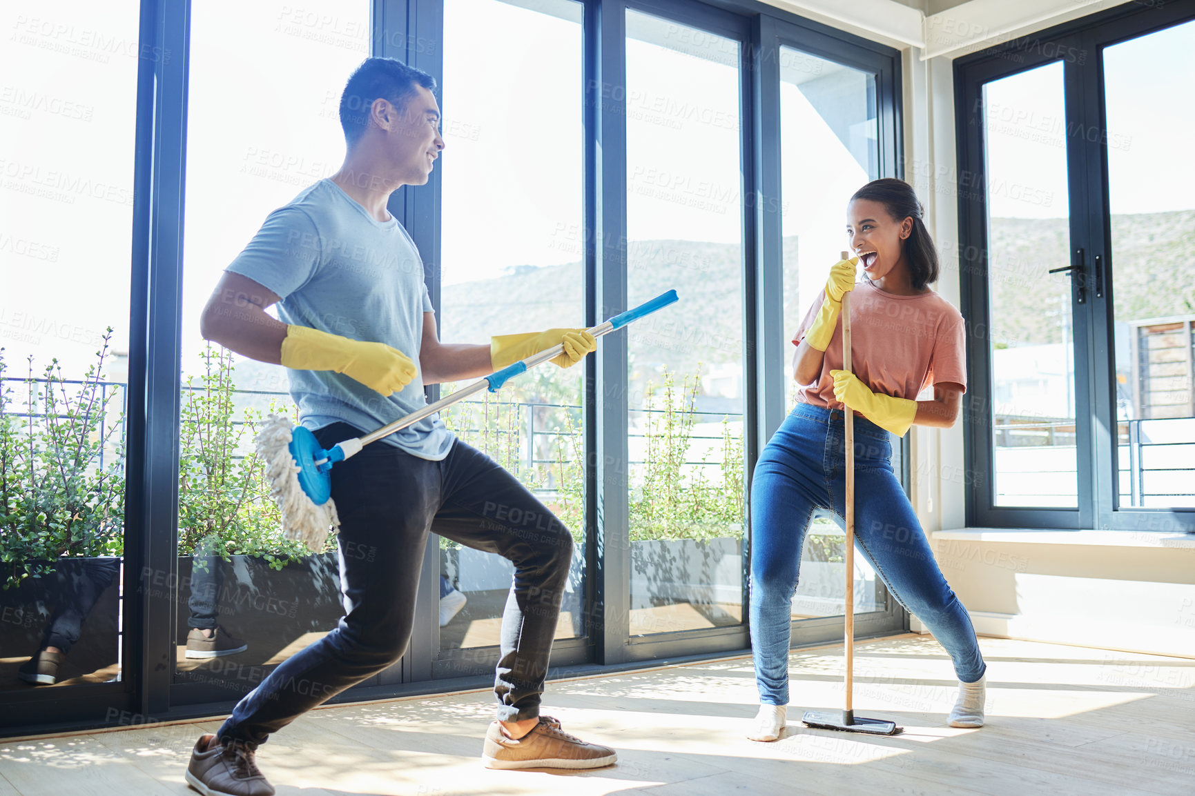 Buy stock photo Couple, singing and cleaning home, dance and having fun playing with mop guitar and broom. Clean, dancing and happy man and woman, singer and chores, housekeeping together and happiness for music.