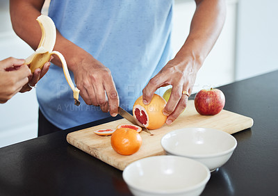 Buy stock photo Shot of a couple peeling and cutting up fruit together