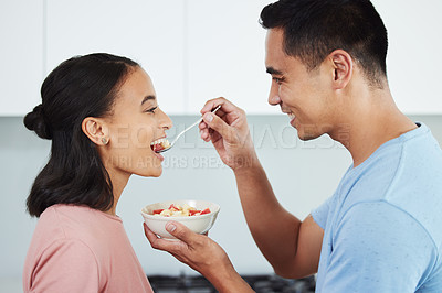 Buy stock photo Shot of a husband feeding his wife food