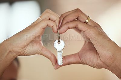 Buy stock photo Shot of a young couple forming a heart shape around the keys to their home with their hands