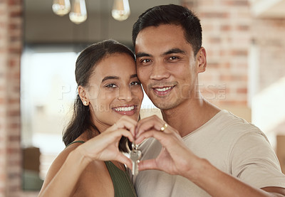 Buy stock photo Shot of a young couple forming a heart shape around the keys to their home with their hands
