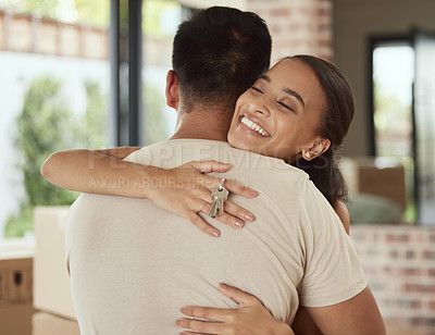 Buy stock photo Shot of a woman embracing her partner while holding the key to their new home