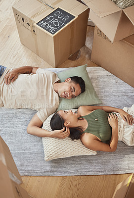 Buy stock photo Shot of a young couple lying on the floor in their new home