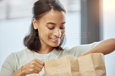 Buy stock photo Shot of a young woman unpacking her food order