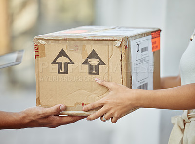 Buy stock photo Shot of a delivery man passing a package to a customer