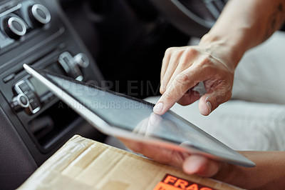 Buy stock photo Shot of a delivery man checking his package on his digital tablet