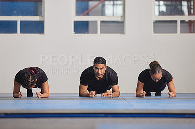 Buy stock photo Shot of three young people training together at the gym