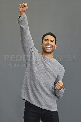 Buy stock photo Celebrate, winner and man in a studio cheering for success, winning or champion achievement. Happiness, excited and male model with fist pump in celebration of a victory isolated by a gray background