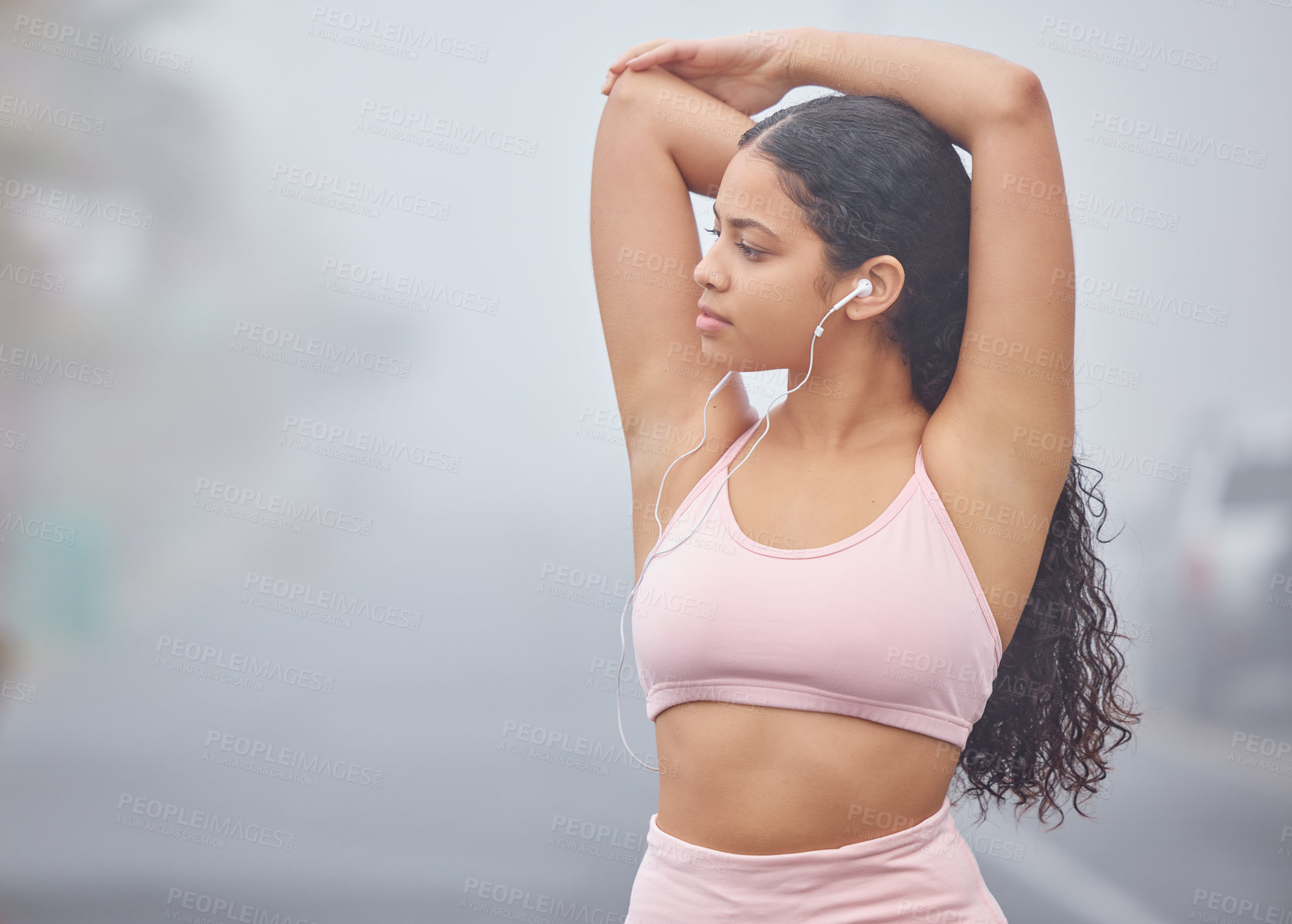 Buy stock photo Shot of a young woman listening to music while doing stretches