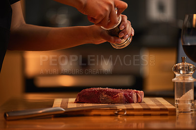 Buy stock photo Shot of a woman seasoning a piece of steak for dinner