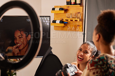 Buy stock photo Shot of a young female model and photographer looking at pictures on a screen at a studio