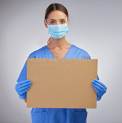 Buy stock photo Shot of a female nurse holding a board for signage against a studio background