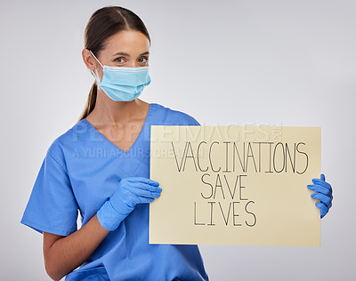 Buy stock photo Shot of a young female nurse holding vaccination signage against a studio background