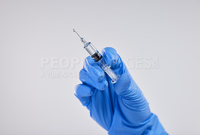 Buy stock photo Shot of a nurse holding a syringe against a studio background