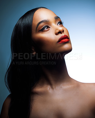 Buy stock photo Shot of an attractive young woman posing against a blue background in the studio