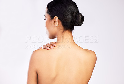 Buy stock photo Rearview shot of a young woman posing with her hand on her shoulder