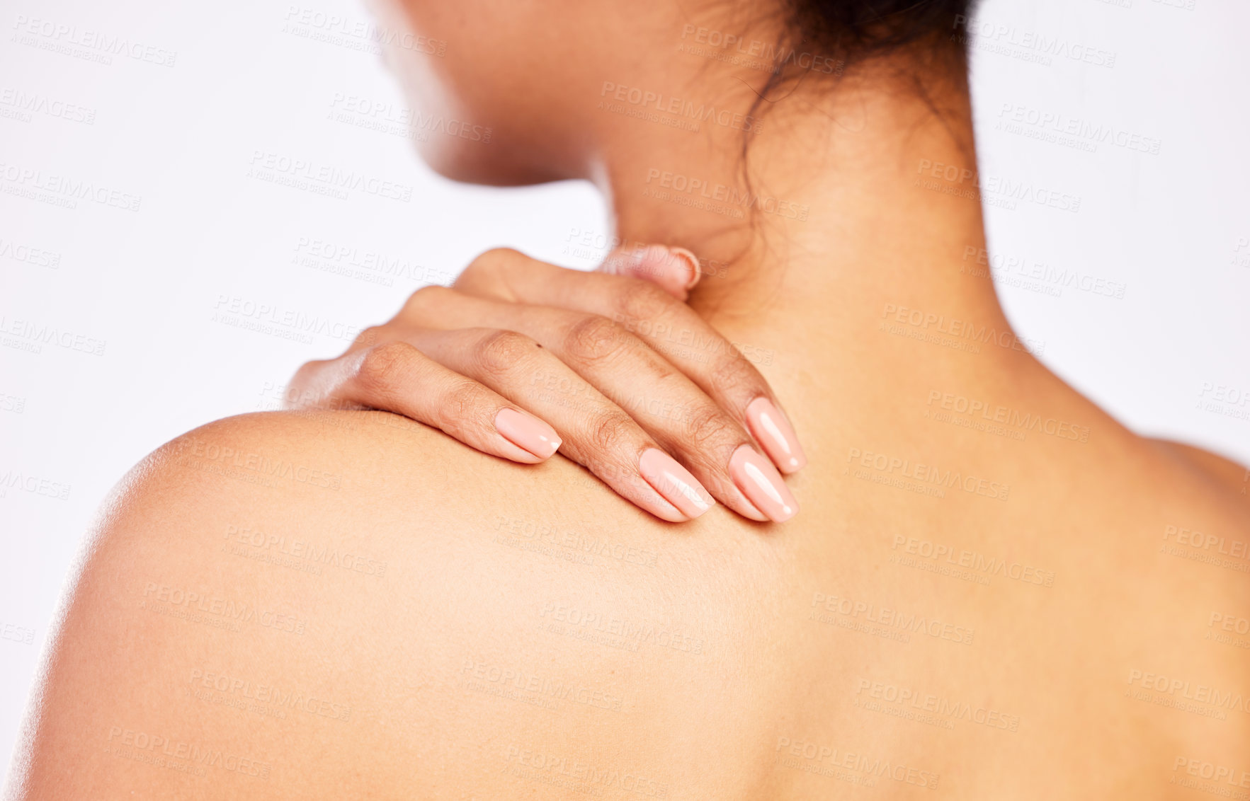 Buy stock photo Rearview shot of a young woman posing with her hand on her shoulder