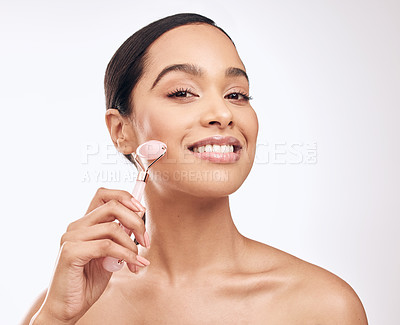 Buy stock photo Studio shot of a young woman holding a derma roller against a white background