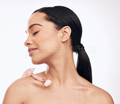 Buy stock photo Studio shot of a young woman posing with a derma roller against a white background