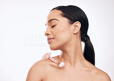 Buy stock photo Studio shot of a young woman posing with a derma roller against a white background