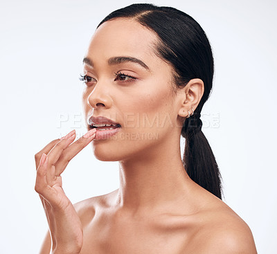 Buy stock photo Shot of a beautiful young woman applying lip balm