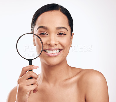 Buy stock photo Shot of a beautiful young woman holding a magnifying glass while posing against a white background