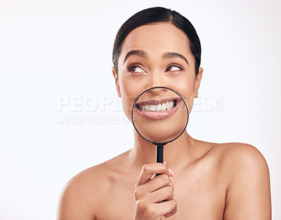 Buy stock photo Shot of a beautiful young woman holding a magnifying glass over her mouth