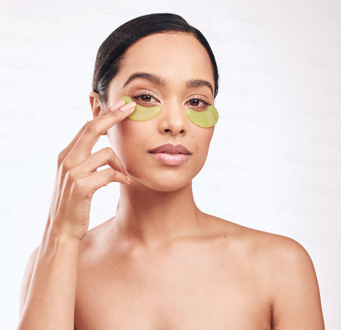 Buy stock photo Studio shot of a beautiful young woman wearing a gel eye mask while standing against a white background