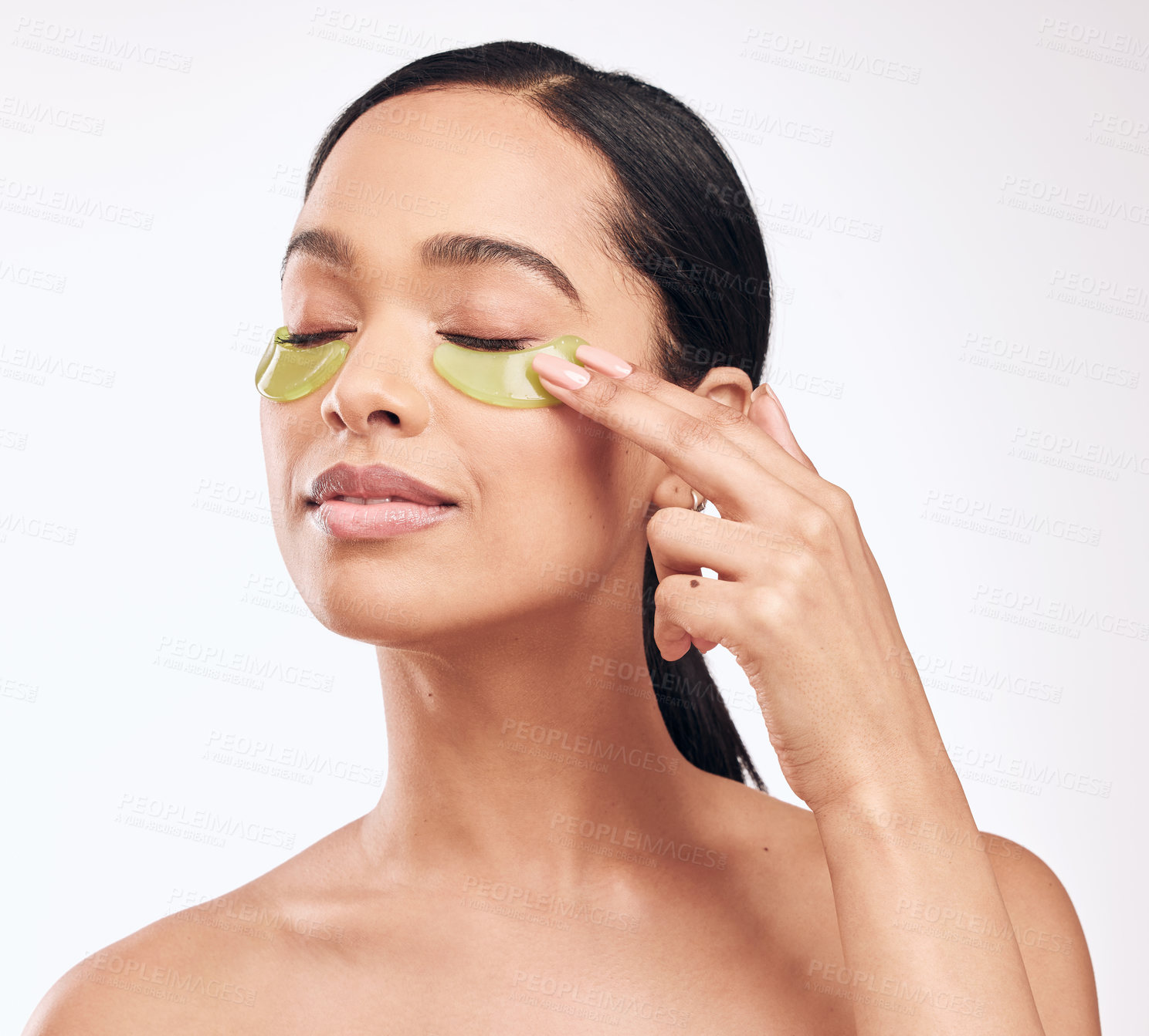 Buy stock photo Studio shot of a beautiful young woman wearing a gel eye mask while standing against a white background