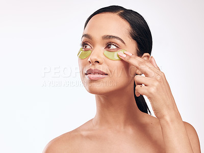 Buy stock photo Studio shot of a beautiful young woman wearing a gel eye mask while standing against a white background