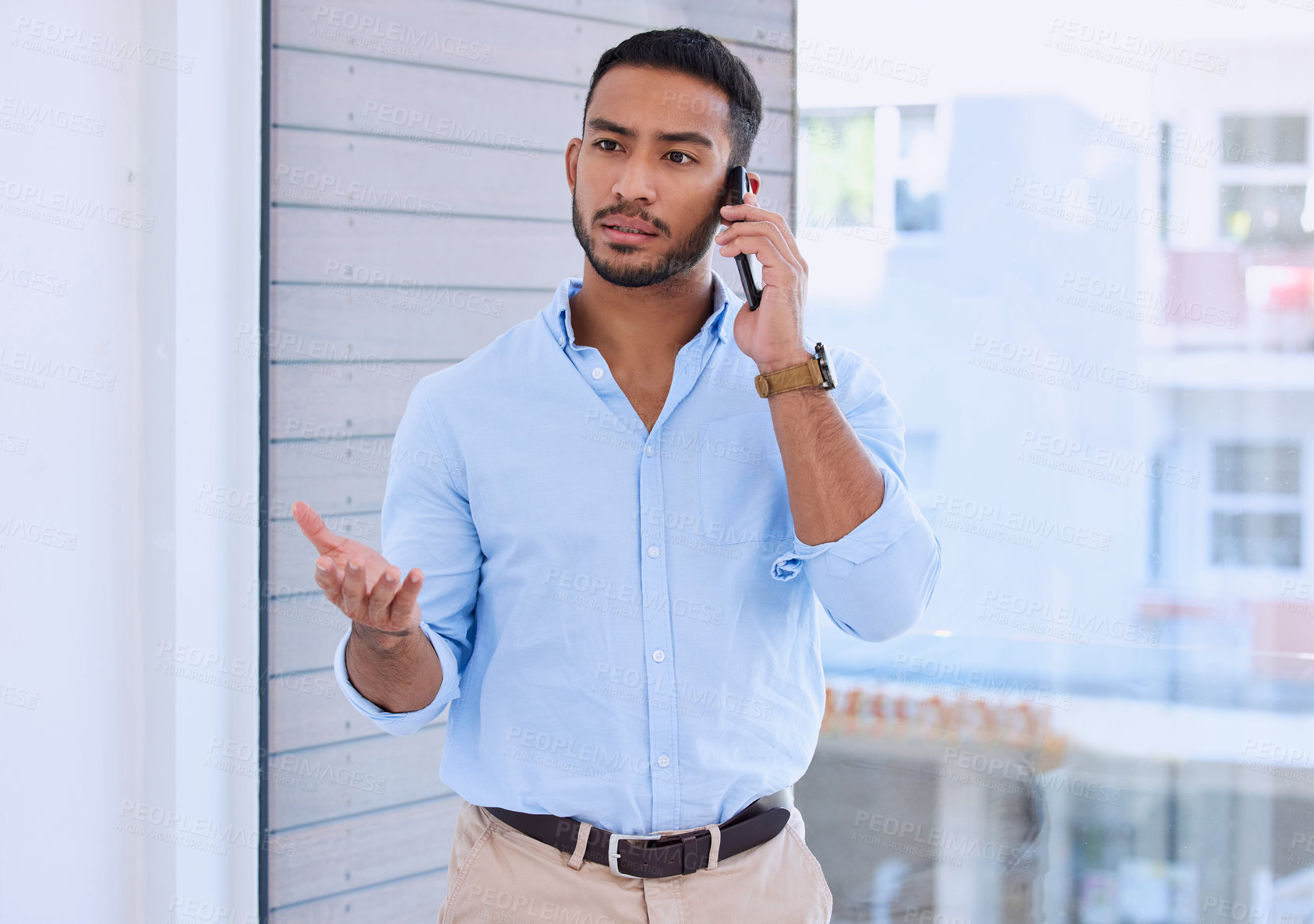 Buy stock photo Shot of a young businessman using his smartphone to make a phone call