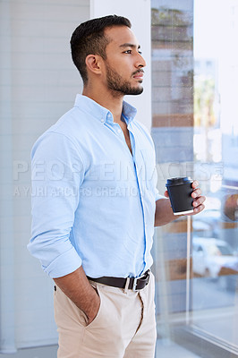 Buy stock photo Shot of a young businessman taking a break to drink some coffee while enjoying the view