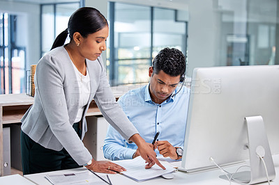 Buy stock photo Shot of an attractive young businesswoman standing and getting her intern agent to sign his contract in the office