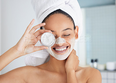 Buy stock photo Shot of an attractive young woman standing alone in her bathroom at home with a face mask on