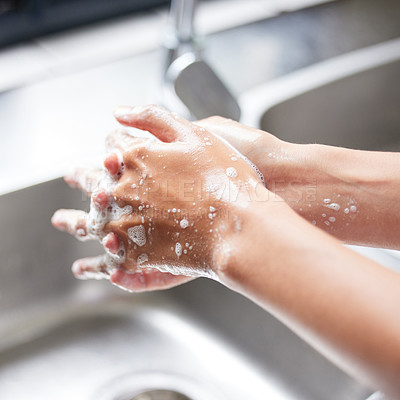 Buy stock photo Cropped shot of an unrecognizable woman washing her hands in the sink at home