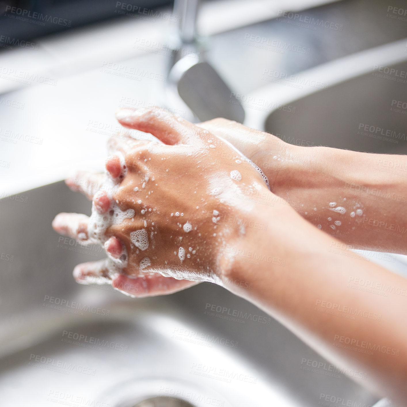 Buy stock photo Cropped shot of an unrecognizable woman washing her hands in the sink at home