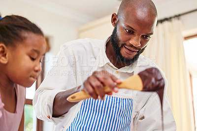 Buy stock photo Shot of an adorable little girl and her father bonding by baking in the kitchen at home