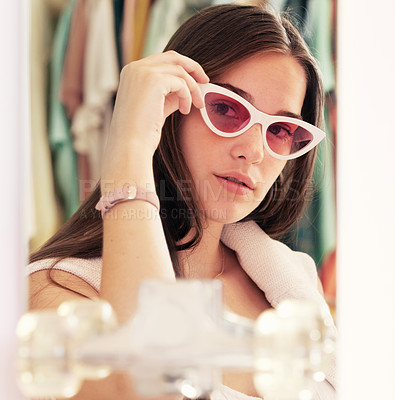 Buy stock photo Shot of a young woman trying on sunglasses while shopping