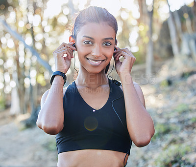 Buy stock photo Sports, portrait and woman with a earphones for music, radio or podcast while running in nature. Fitness, exercise and female athlete doing cardio workout for race or marathon training in the woods.