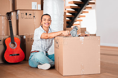 Buy stock photo Shot of a young woman sealing cardboard boxes with sellotape at home
