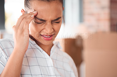Buy stock photo Shot of a woman suffering from a headache at home