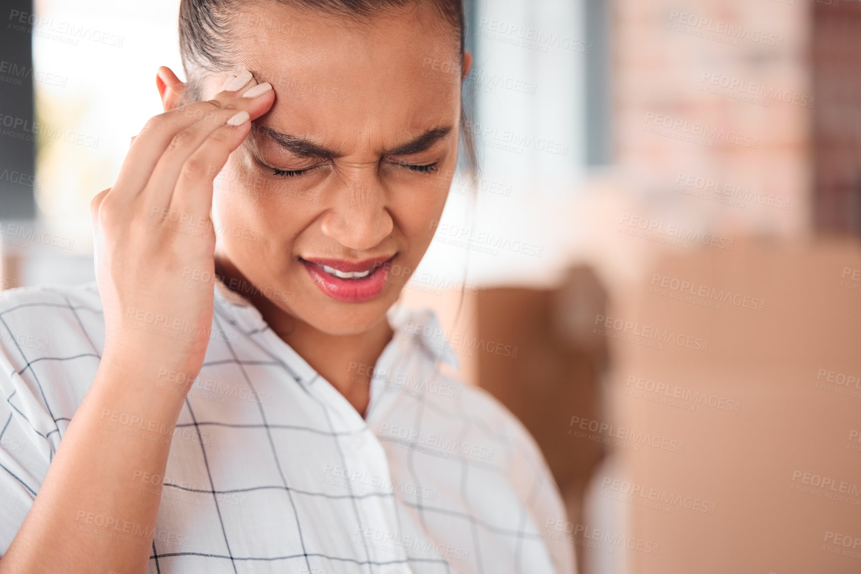 Buy stock photo Shot of a woman suffering from a headache at home
