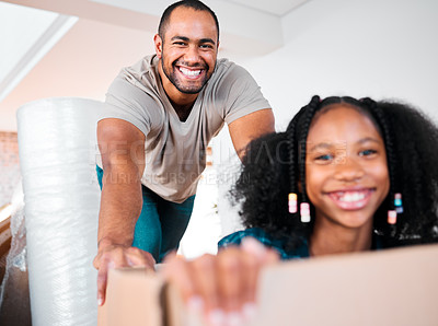 Buy stock photo Shot of a man pushing his daughter around in a cardboard box in their new home